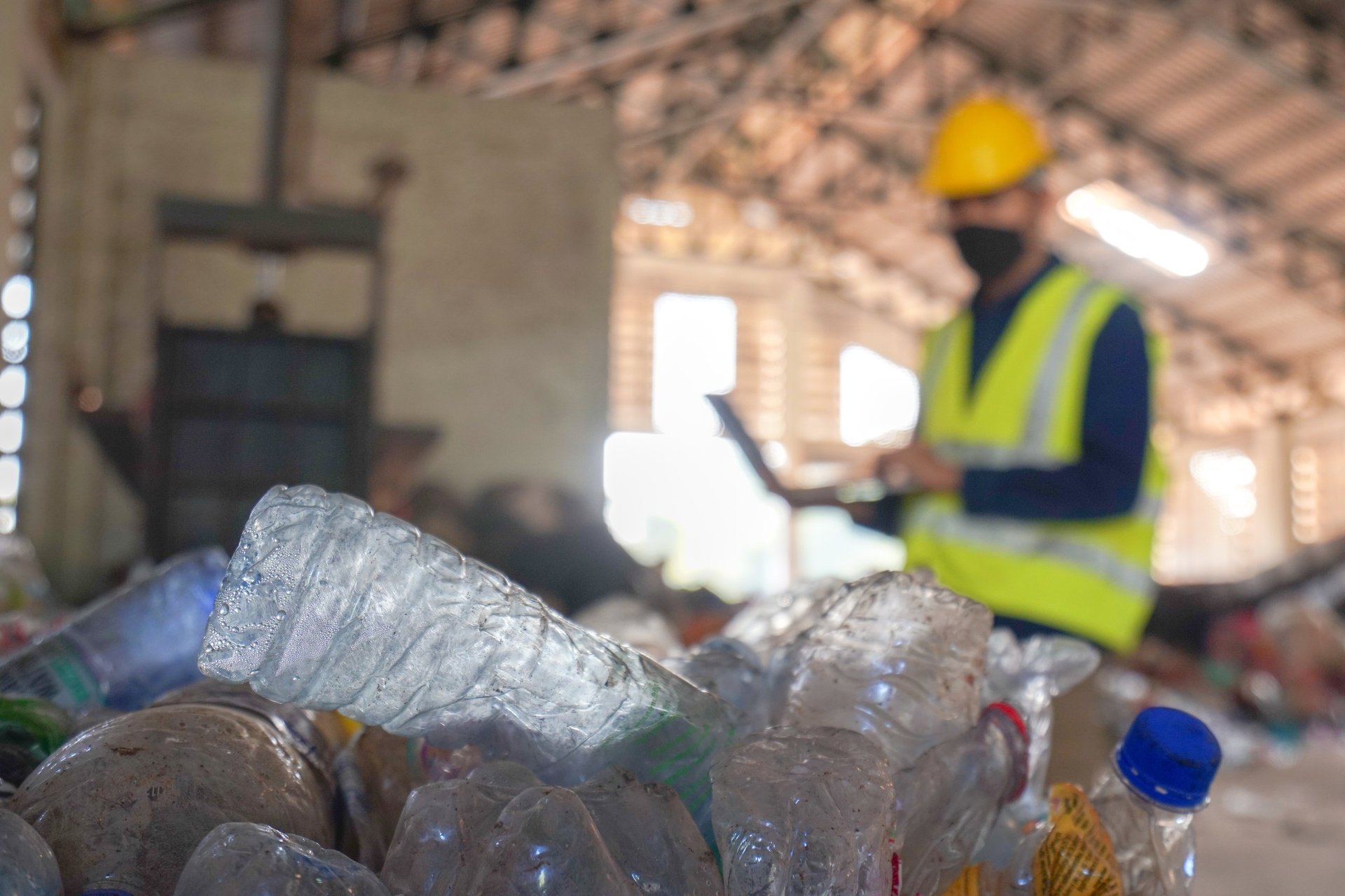 Environmental engineer inspecting waste plastic at recycling facility