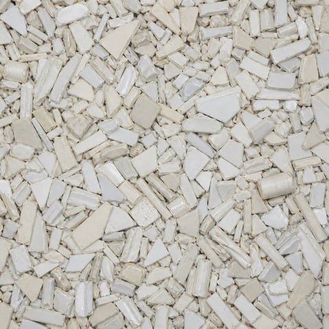 Close-up of white and cream-colored crushed stone or gravel pieces scattered across a surface